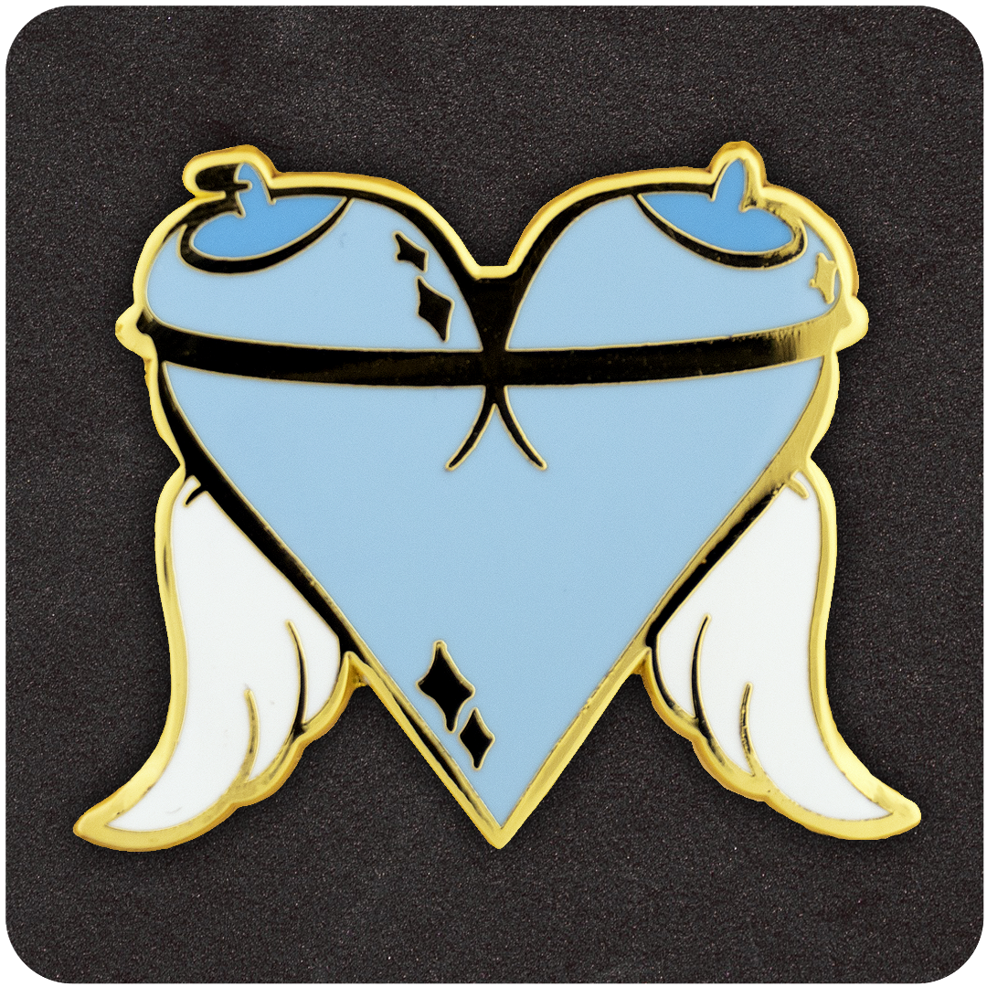 Angel Tits enamel pin shaped like a heart formed by two blue cartoon breasts with halo-tipped nipples, a black strap across the chest, white angel wings, and gold metal outlining.