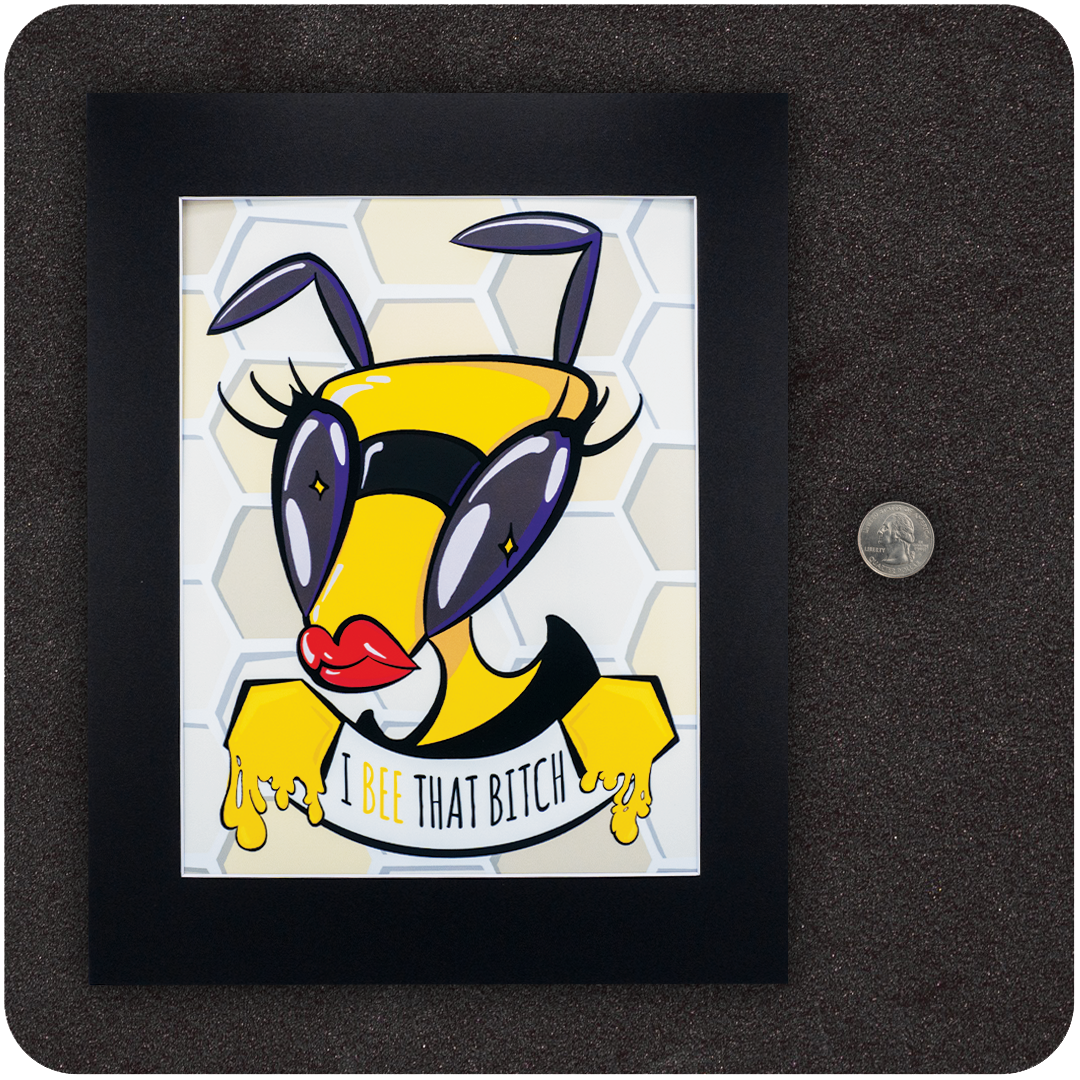 Framed art print of a fierce cartoon bee with oversized eyes, red lips, and honey-dripping hands holding a banner that reads “I Bee That Bitch.” Set against a honeycomb background with a U.S. quarter shown beside the frame for scale reference.