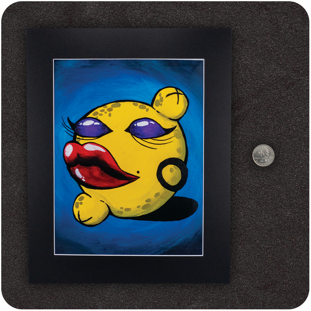 Framed art print titled “Pussy Pop Lemon Drop” featuring a sassy anthropomorphic lemon with red lips and purple eyeshadow, shown with a U.S. quarter for size reference. Black matted frame rests on a textured black surface.