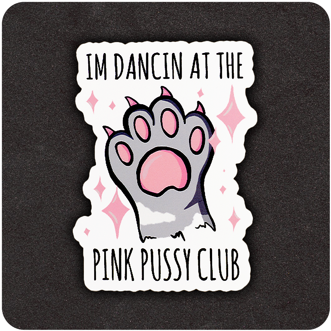 A die-cut vinyl sticker featuring a cartoon-style paw with pink pads and claws raised in the center, surrounded by sparkling pink stars. The top text reads “I’M DANCIN AT THE,” and the bottom text says “PINK PUSSY CLUB.” The design is set against a black background.