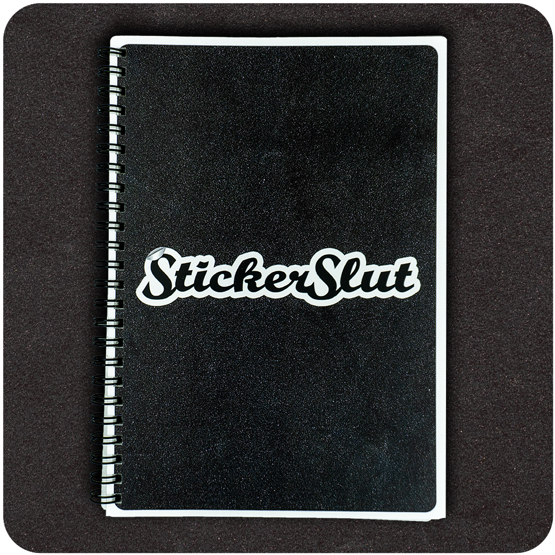 The Casual Covert Sticker Slut Reusable Sticker Collecting Book. A black sticker book with the words "sticker slut" on the front.