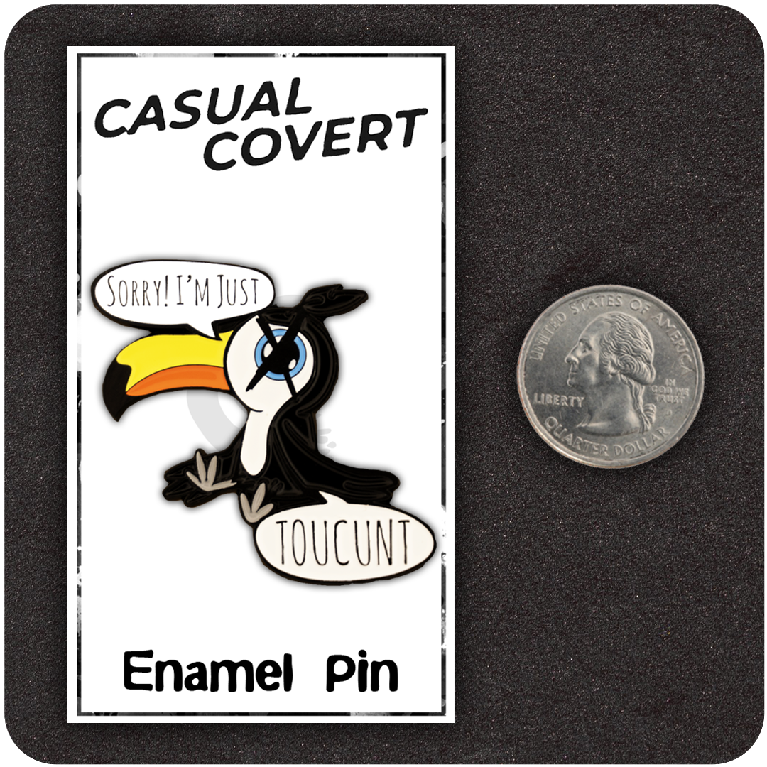 Funny enamel pin of a cartoon toucan with exaggerated features, speech bubbles reading “Sorry! I’m Just TOUCUNT,” shown next to a U.S. quarter for size reference, on a branded Casual Covert display card.