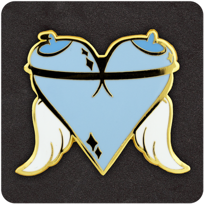 Angel Tits enamel pin shaped like a heart formed by two blue cartoon breasts with halo-tipped nipples, a black strap across the chest, white angel wings, and gold metal outlining.