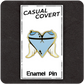 The Casual Covert Angel Tits Enamel Pin on its backing card showing how the customer receive said enamel pin.
