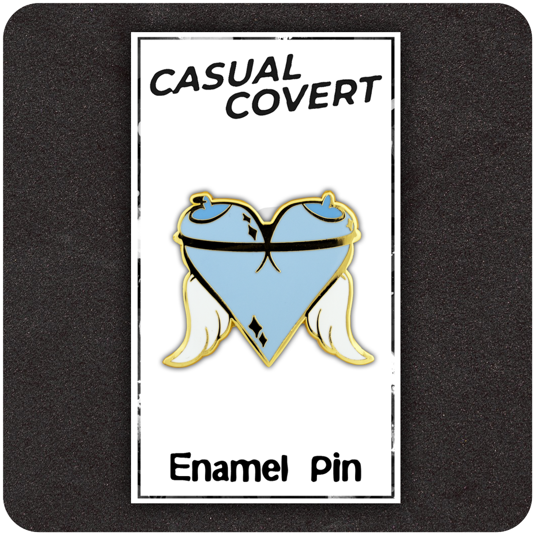 The Casual Covert Angel Tits Enamel Pin on its backing card showing how the customer receive said enamel pin.