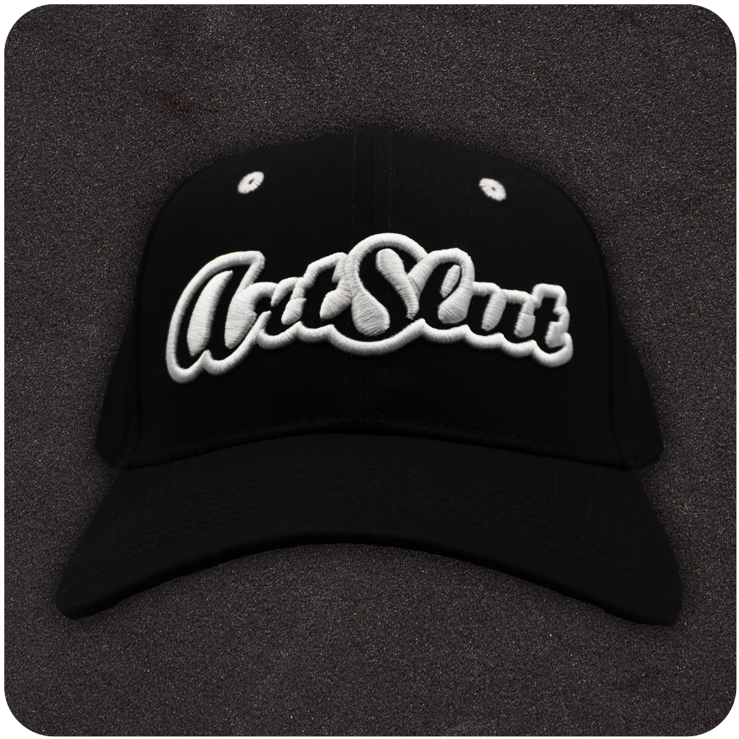 The Casual Covert Art Slut Snapback Hat. A black snapback hat with 3D white embroidery of the word "art slut" on the front of the cap.