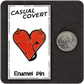 The Casual Covert Demon Tits Enamel Pin next to a quarter for scale.