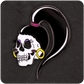 The Casual Covert Drag Me To Hell Enamel Pin. Shows a skull black enamel pin with eyeshadow. earrings, blush, and a pony tail.