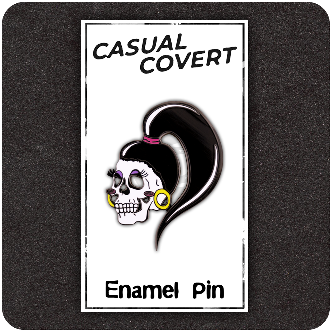 The Casual Covert Drag Me To Hell Enamel Pin on a backing card to show customers how the pin is shipped.