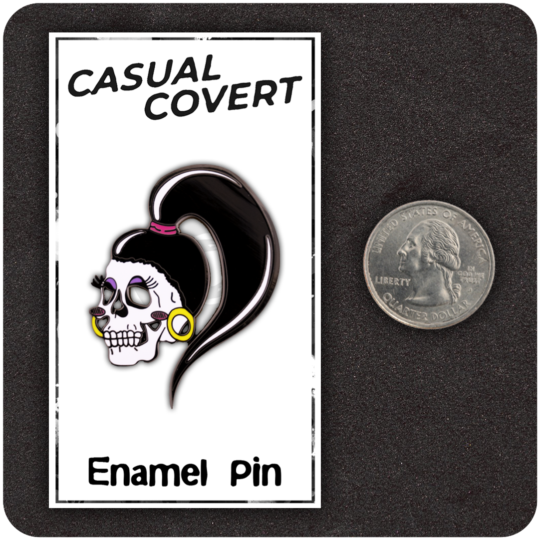 The Casual Covert Drag Me To Hell Enamel Pin next to a quarter to show scale. 