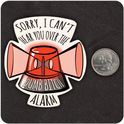 A vibrant vinyl sticker depicting a red emergency alarm siren with pink megaphones extending from each side. Black curved text above the siren reads, “SORRY, I CAN’T HEAR YOU OVER THE,” while the base of the alarm displays the words “DUMB BITCH ALARM.” A U.S. quarter is placed beside the sticker to show its size, all set against a dark textured background.