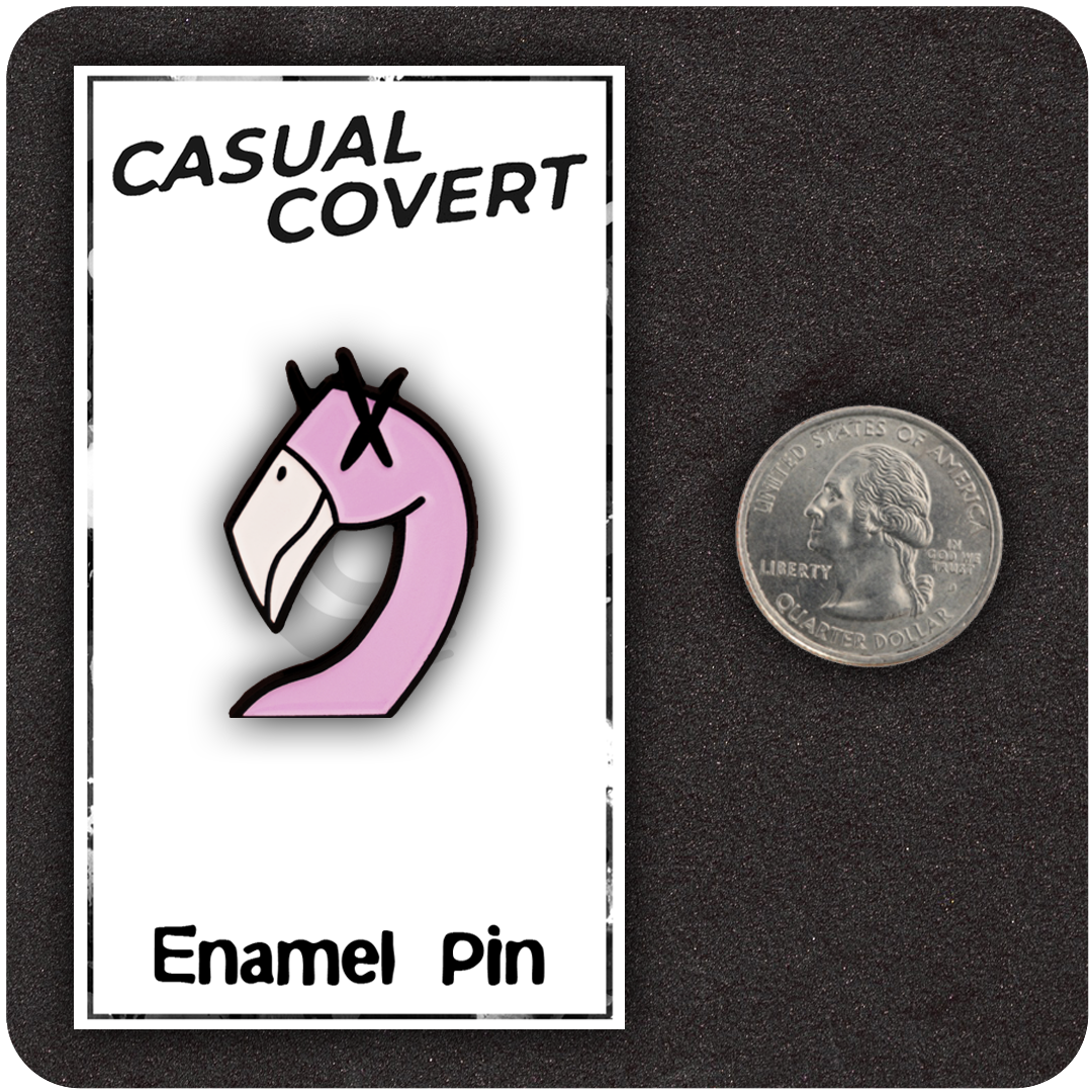 The Casual Covert Flamingo Enamel Pin next to a quarter to show scale.