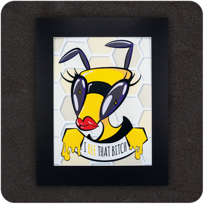 Framed art print featuring a bold cartoon bee with red lips, oversized purple eyes, and dramatic lashes, posed confidently in front of a honeycomb background. Below the bee, the text reads “I Bee That Bitch” in a playful font with honey dripping from its hands.