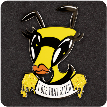 Sassy enamel pin featuring a fierce cartoon bee with bold eyelashes, orange lips, and a dripping honey banner that reads “I Bee That Bitch.” Set against a dark foam background.
