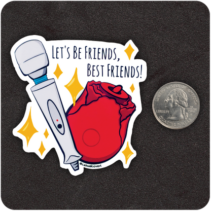 A die-cut sticker on a black background featuring a cartoon-style white wand vibrator and red rose-shaped toy surrounded by yellow sparkles. The text above reads “LET’S BE FRIENDS, BEST FRIENDS!” A U.S. quarter coin is placed beside the sticker for size reference. The artist handle “@casualcovert” is printed at the bottom of the design.