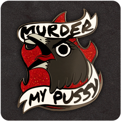 Bold enamel pin featuring a fierce cartoon bird with red glitter flames in the background and a banner that reads “Murder My Pussy,” set against a black foam display backing.