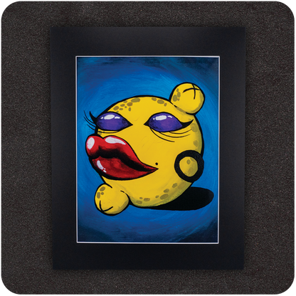 Colorful framed art print featuring a bold, anthropomorphic yellow lemon with exaggerated red lips, purple eyeshadow, hoop earring, and flirty expression against a rich blue background. Presented in a sleek black mat for a gallery-style finish.