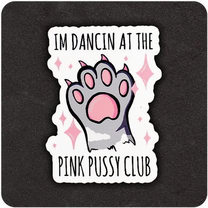 A die-cut vinyl sticker featuring a cartoon-style paw with pink pads and claws raised in the center, surrounded by sparkling pink stars. The top text reads “I’M DANCIN AT THE,” and the bottom text says “PINK PUSSY CLUB.” The design is set against a black background.