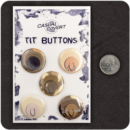 Set of five Casual Covert “Tit Buttons” enamel pins featuring diverse cartoon nipples with unique styles and piercings, displayed on branded backing card next to a U.S. quarter for size reference — playful, body-positive flair pins.